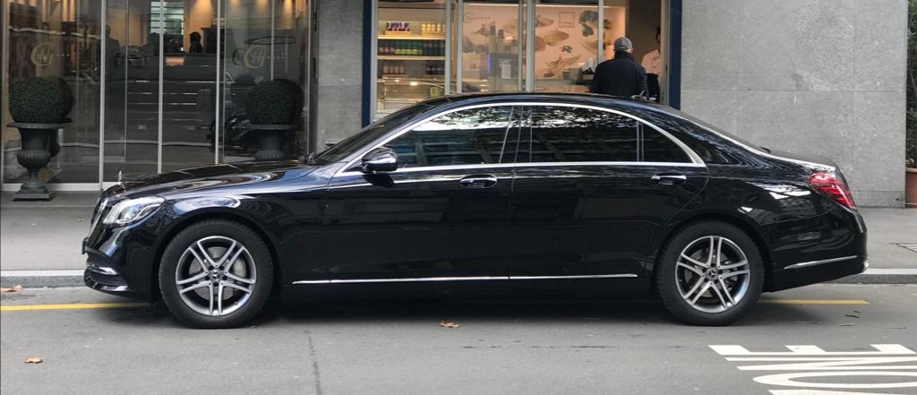 black mercedes s class limousine in front of a hotel in zurich city ready for the next airport transfer