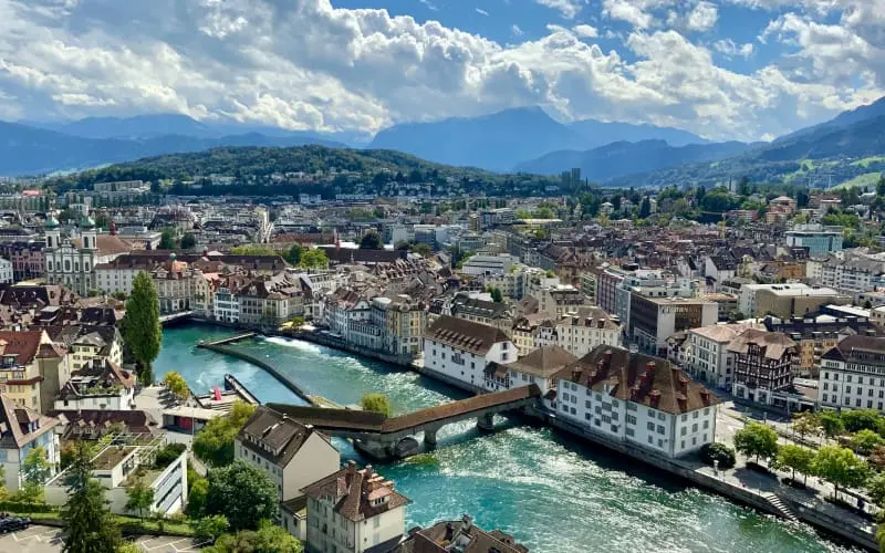  a panoramic view of Lucerne featuring its river and bridges, with a backdrop of the city's architecture