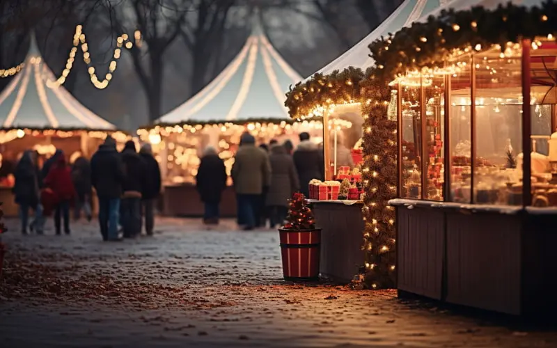A Christmas market with lights and people walking around